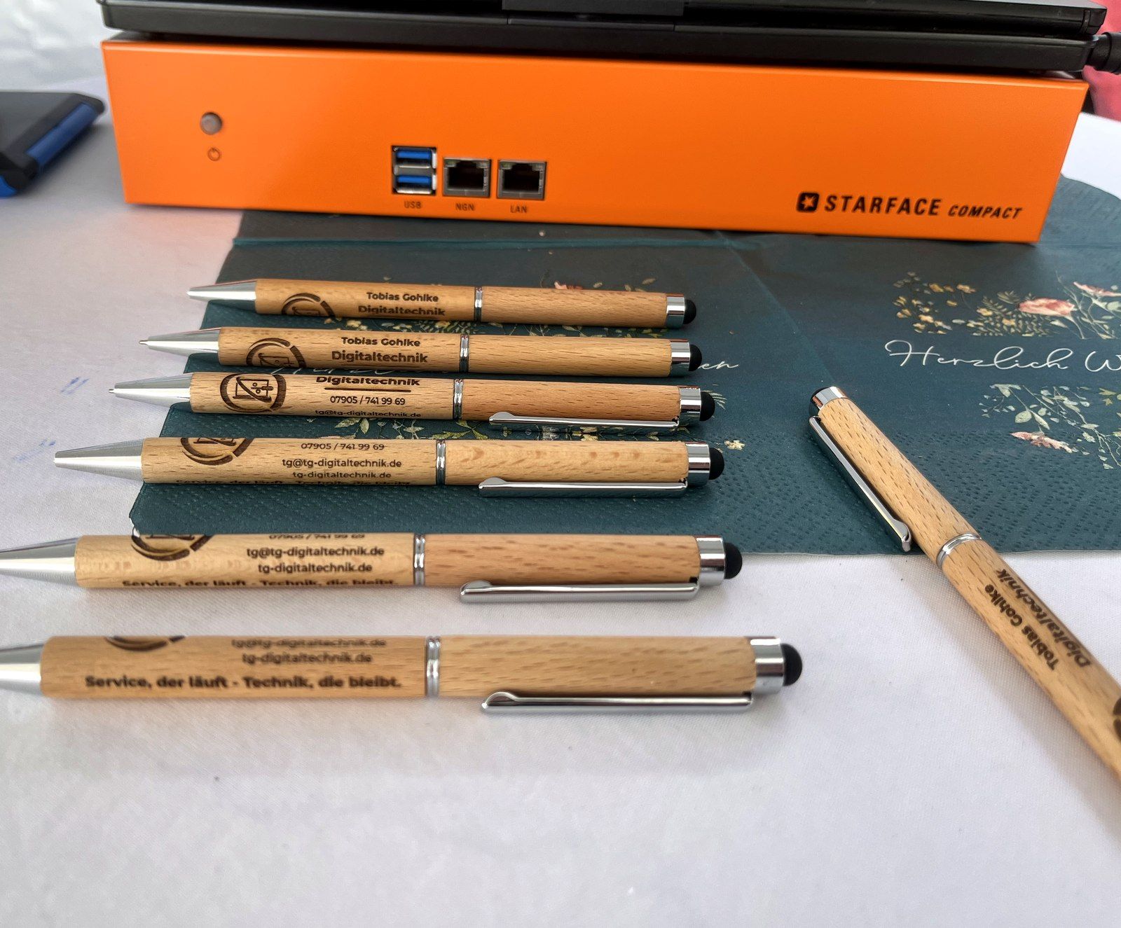 STARFACE Compact Telefonanlage mit Anschlüssen, daneben gravierte Marken-Stifte von Tobias Gohlke - Digitaltechnik