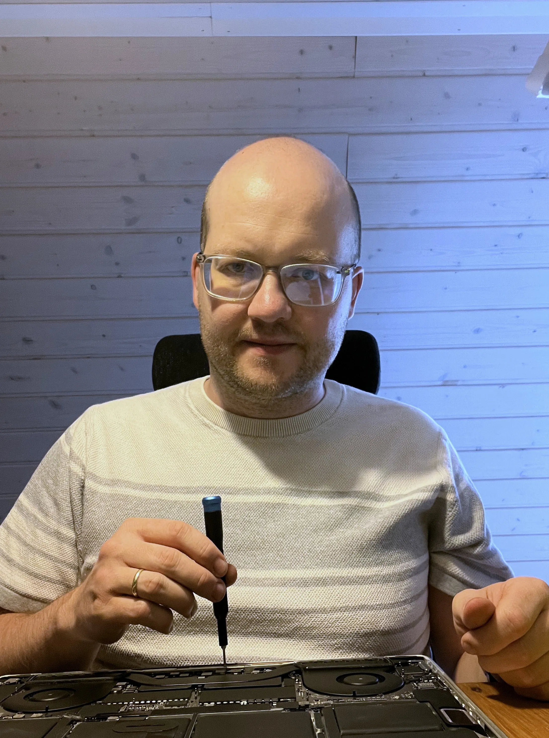 Tobias Gohlke repariert ein geöffnetes MacBook in seiner Werkstatt